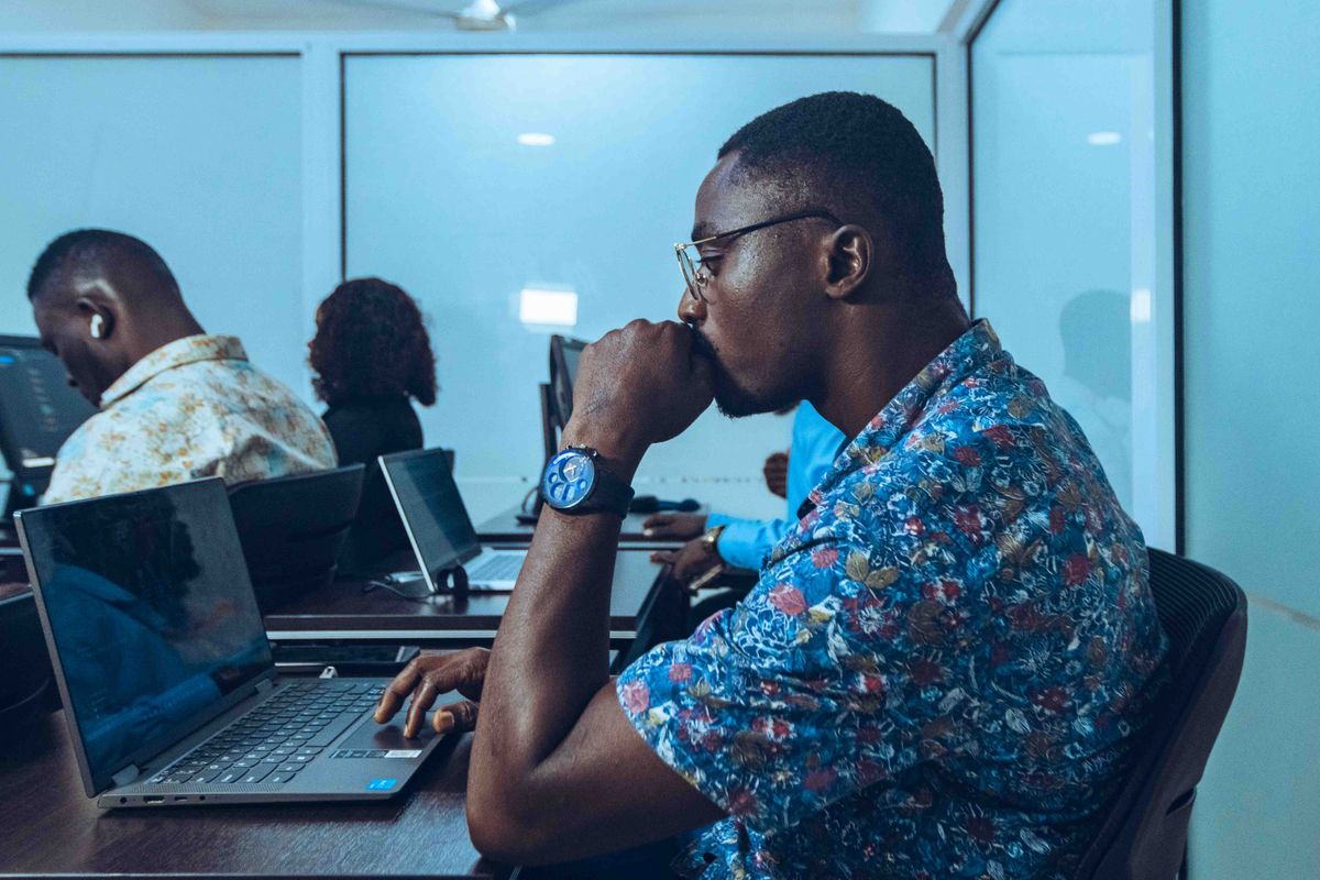 Formateur accompagnant un apprenant sur poste informatique